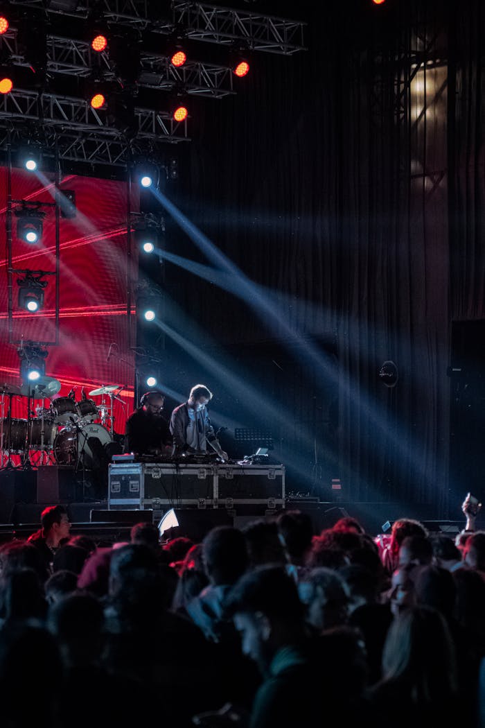 Energetic DJ set at a vibrant concert with colorful lights and a lively audience.