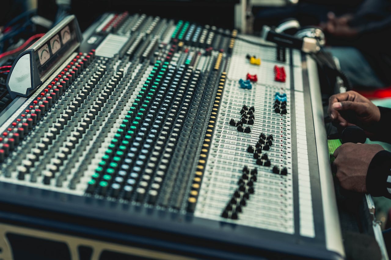 A close-up view of a professional audio mixing console in use by a sound engineer.