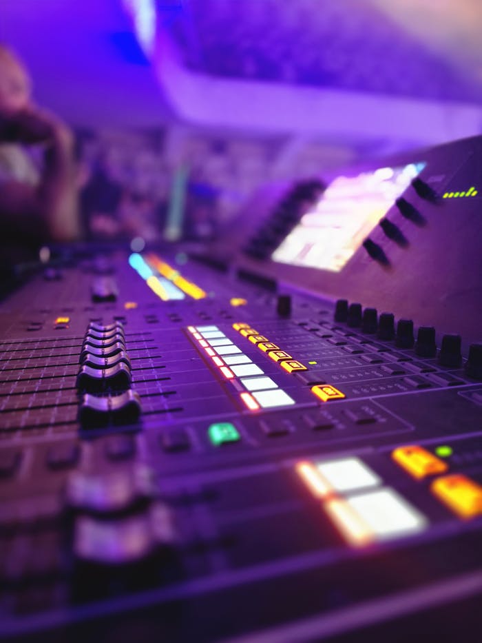 Dynamic shot of a colorful audio mixing console with illuminated controls, ideal for music production themes.